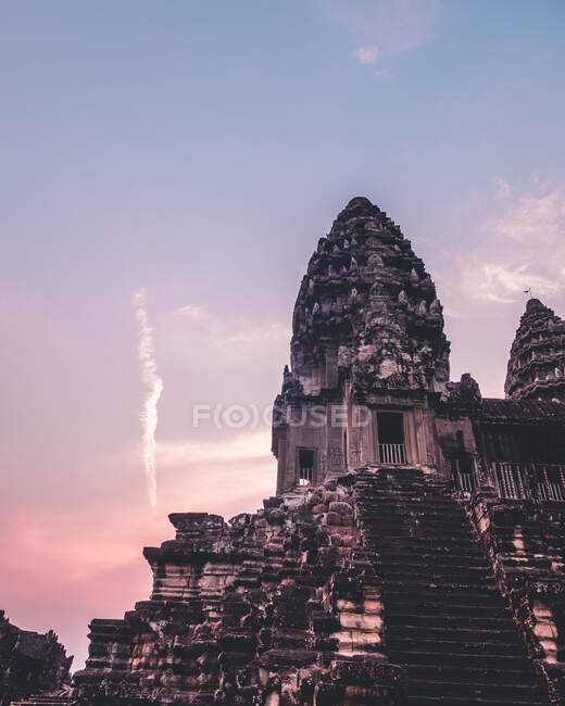 Чудовий храм у Камбоджі з пурпуровим сонцем. — стокове фото