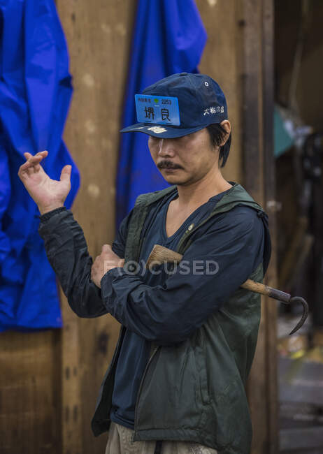 Hombre dando señal de mano en el mercado de pescado Tsukiji en Tokio - foto de stock