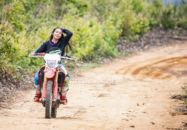 Donna in sella alla sua moto sporcizia su pista forestale in Pak Chong / Thailandia — Foto stock