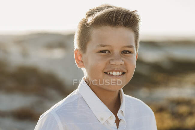 Lächelnder, sauber geschnittener Frühchen-Junge im weißen Hemd mit Knopfdruck — Stockfoto