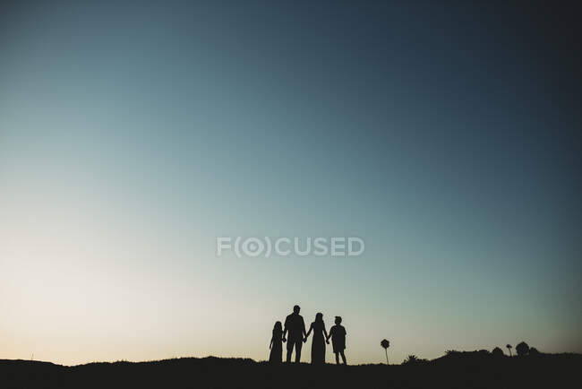 Silhouette of family against teal sky — Stock Photo