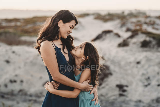 Bonne mère étreignant 8 ans fille à la plage — Photo de stock