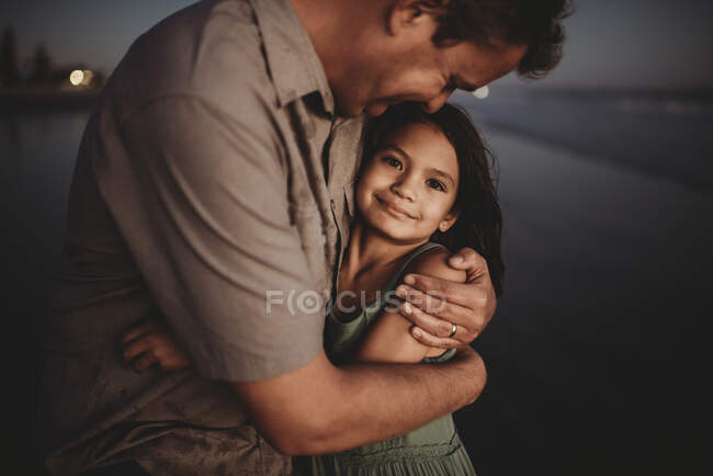 Loving father embracing beautiful 8 yr old daughter with dark eyes — Stock Photo
