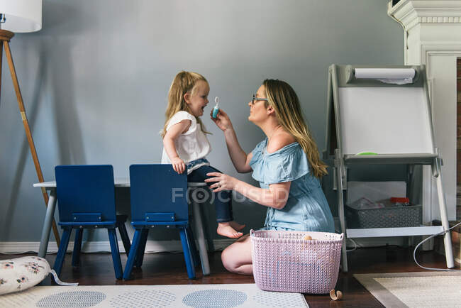 Mère et fille jouant au docteur ensemble dans la salle familiale — Photo de stock