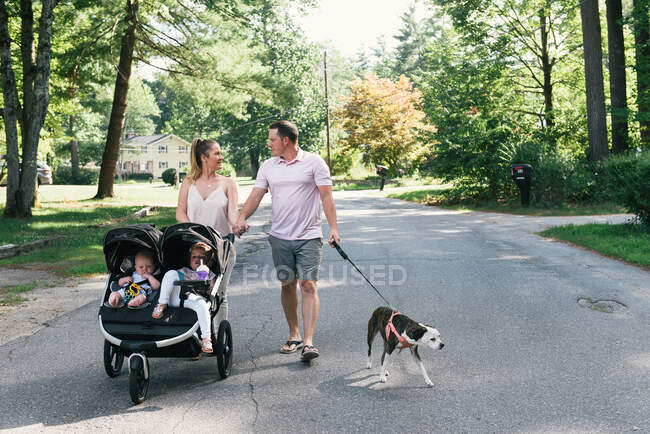 Happy young family walking together with kids and dog outdoors — Stock Photo