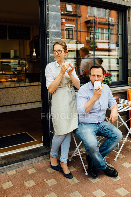 Couple of cafe owners drinking tea at their cafe — Stock Photo