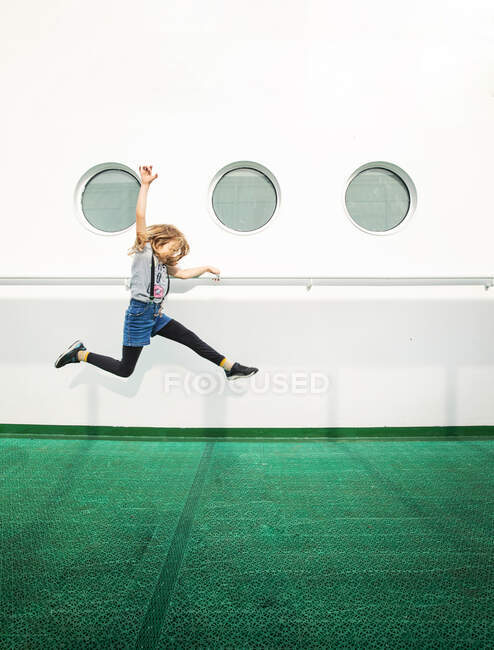 Young Girl Jumping By Windows on A CruiseFerry in the Gulf of Finland — Stock Photo