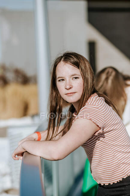 Vertical portrait of preteen standing on the side of ice rink — Stock Photo