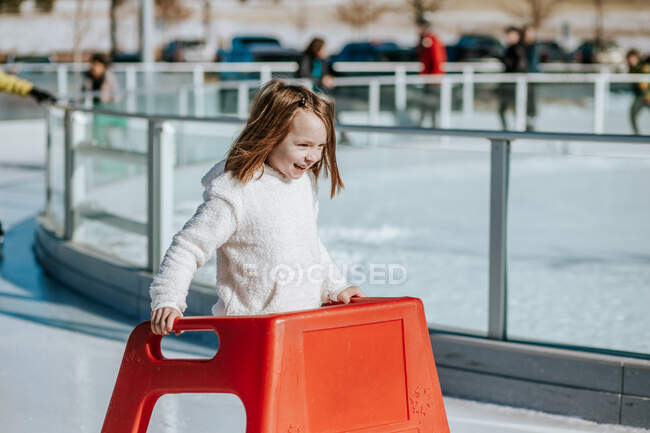Young girl learning how to ice skate on a sunny winter day — Stock Photo