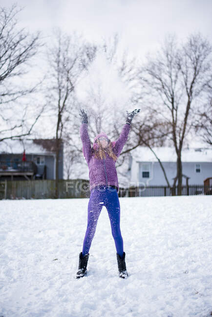 Pré adolescente jogando neve no ar fora no inverno — Fotografia de Stock