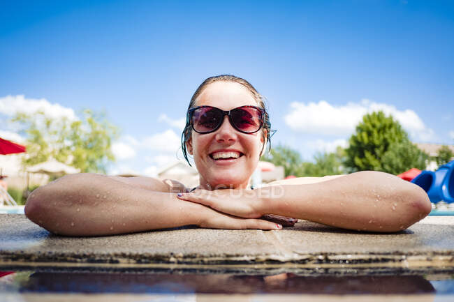 Smiling woman in a pool on a hot summer day — Stock Photo