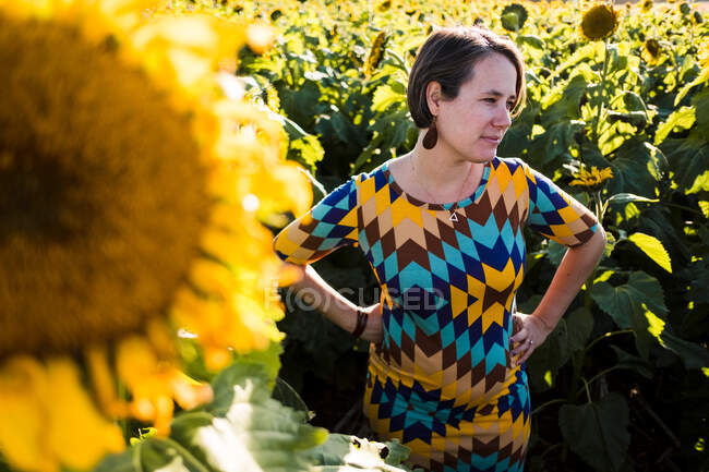 Frau steht in einem Sonnenblumenfeld in der Stadt Kansas — Stockfoto