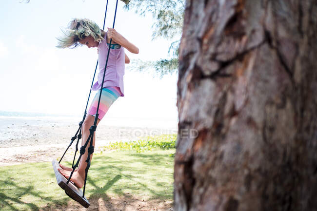 Girl on a swing by the ocean in hawaii — Stock Photo