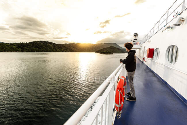 Adolescente en barco viajando entre islas en Nueva Zelanda - foto de stock