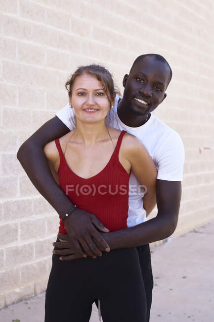 Hombre afroamericano abraza a su novia blanca - foto de stock