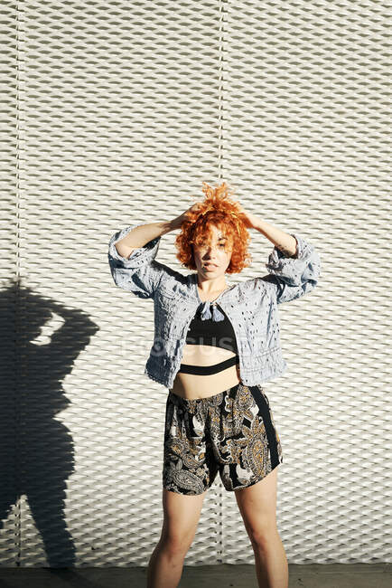 Young alternative redhead girl posing in a metal wall — Stock Photo