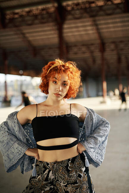 Young alternative redhead girl posing in a hangar — Stock Photo