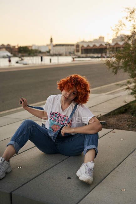 Young alternative redhead girl posing at sunset in a overall — Stock Photo