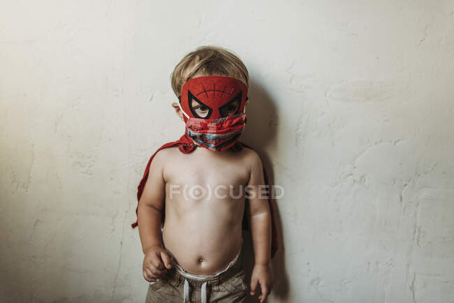 Малыш, стоящий в костюме Хэллоуина и маске для лица — стоковое фото