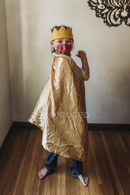 Мальчик школьного возраста в костюме короля в маске для лица — стоковое фото