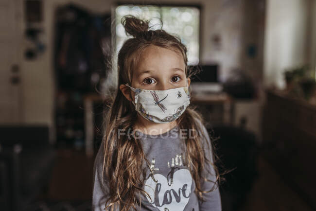 Close up portrait of young preschool aged brunette girl with mask on — Stock Photo