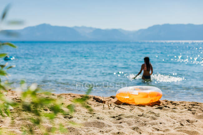 Swimmer in Sunshine at a Mountain Lake with an Inflatable — Stock Photo