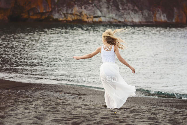 Giovane ragazza bionda che balla sulla spiaggia — Foto stock