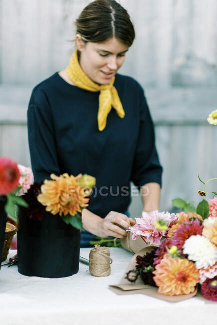 Millennial woman working at her flower farm making bouquets — Stock Photo
