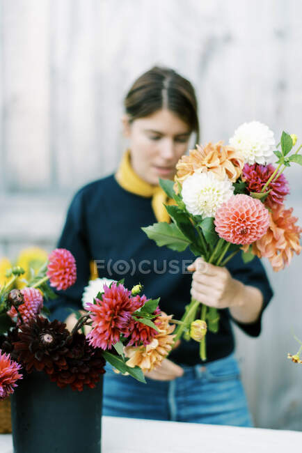 Female business owner and flower farmer arranging dahlia bouquets — Stock Photo