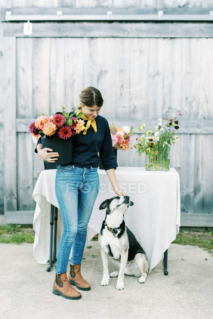 Propietaria y agricultora de flores con su perro - foto de stock