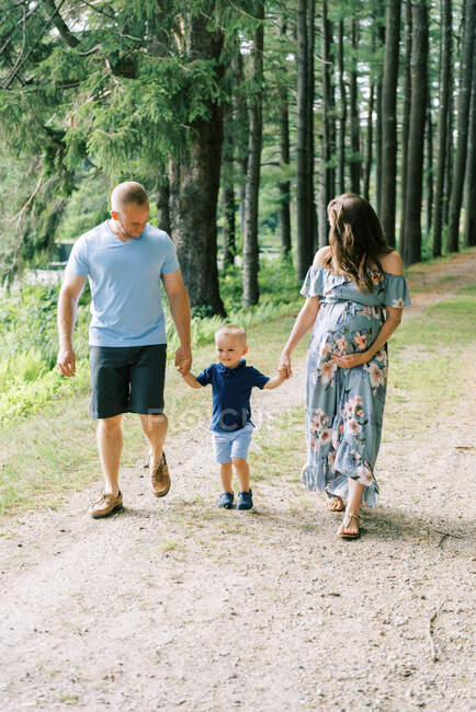 Una famiglia in passeggiata nel parco con una madre incinta — Foto stock