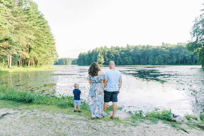 Una familia disfrutando de un tiempo juntos junto a un lago - foto de stock