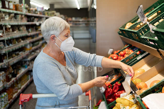 Старша жінка купує в супермаркеті — стокове фото