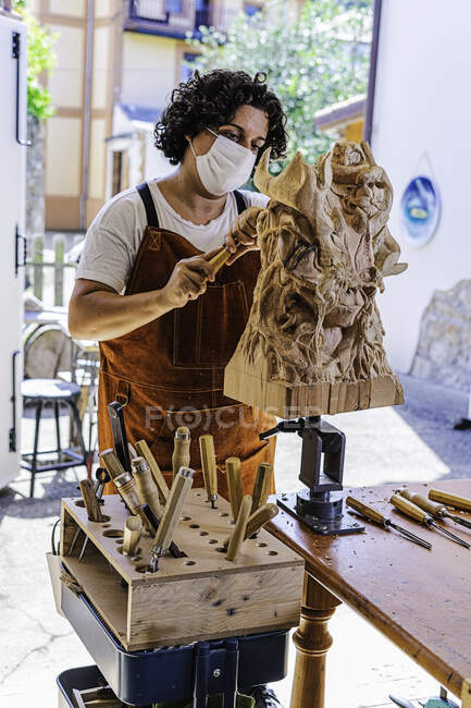 Escultor niña trabaja con un cuchillo y madera en el estudio - foto de stock