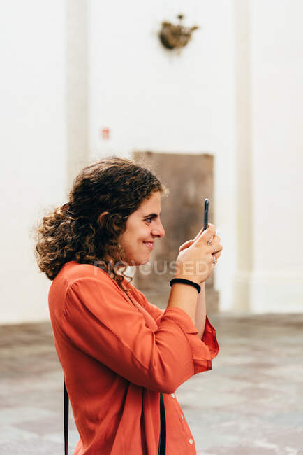 Радостная молодая женщина фотографирует со своим смартфоном. Концепция путешествия и позитив — стоковое фото