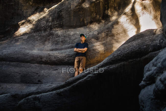 Tens boy leaning up against rock — Stock Photo
