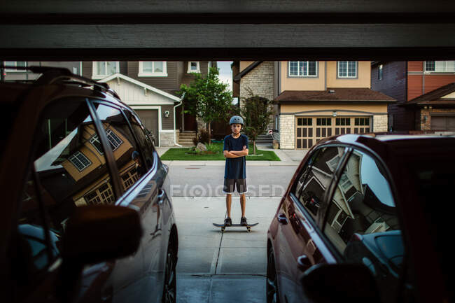 Adolescente chico en monopatín desde el garaje - foto de stock