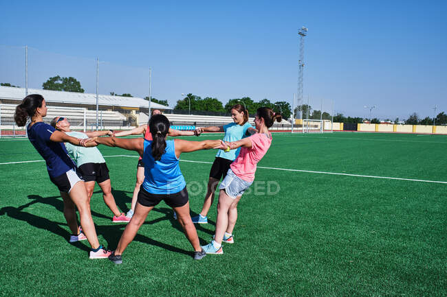 Group of young women practice stretching after their training — Stock Photo