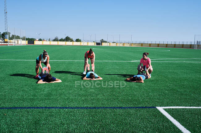 Группа молодых женщин практикует растяжку после тренировки — стоковое фото