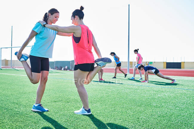 Várias mulheres jovens praticam alongamento após treinamento — Fotografia de Stock