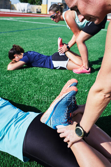 Several young women practice stretching after training — Stock Photo
