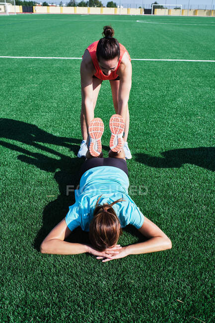 Two women help each other practice their stretching — Stock Photo