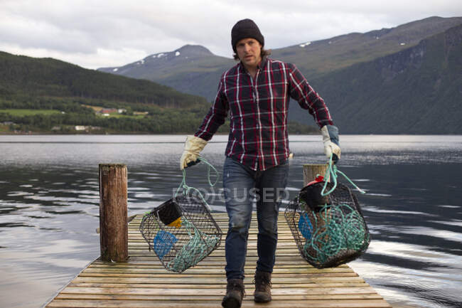 Un Norvégien avec des pots de crabe près du fjord — Photo de stock