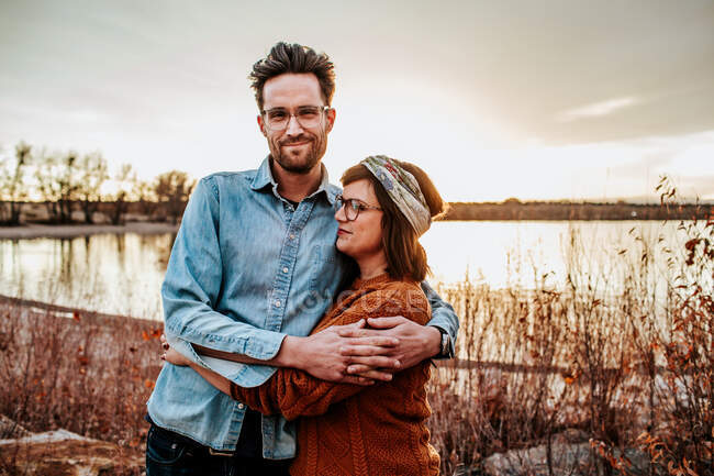 Glückliches Paar, das sich an einem Herbstabend an einem See in Denver CO umarmt — Stockfoto