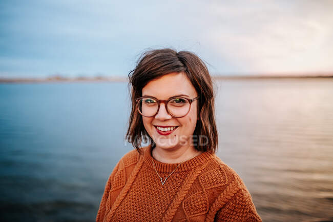 Centro Retrato de uma mulher usando óculos perto de um lago — Fotografia de Stock