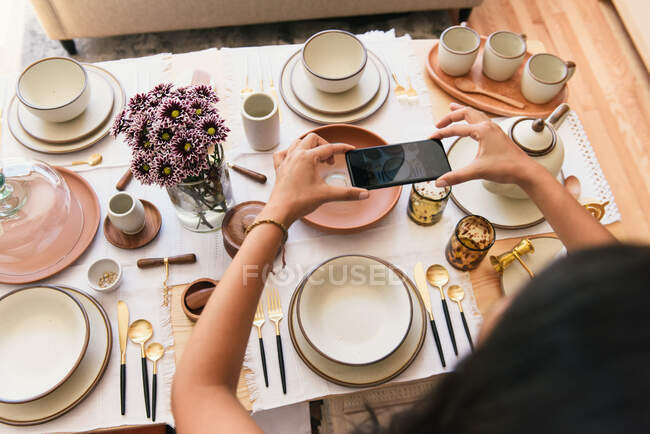 Woman taking photo of table display at boutique craftsman home store — Stock Photo