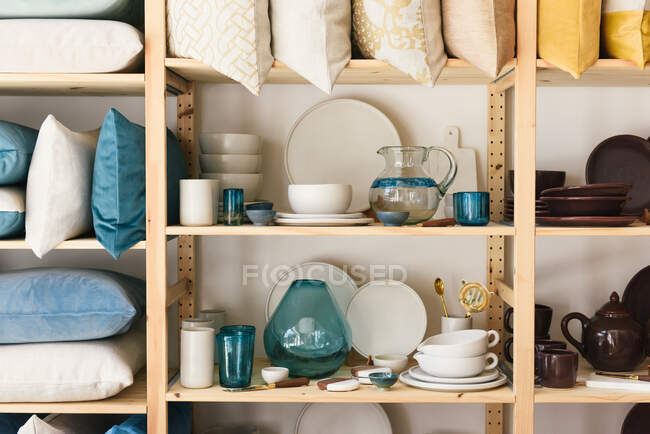 Set di piatti diversi puliti sugli scaffali in camera — Foto stock