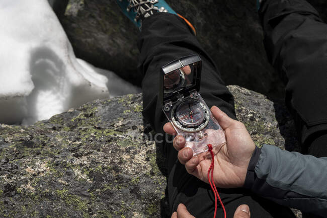Closeup bússola contemporânea na mão das mulheres em montanhas com neve — Fotografia de Stock