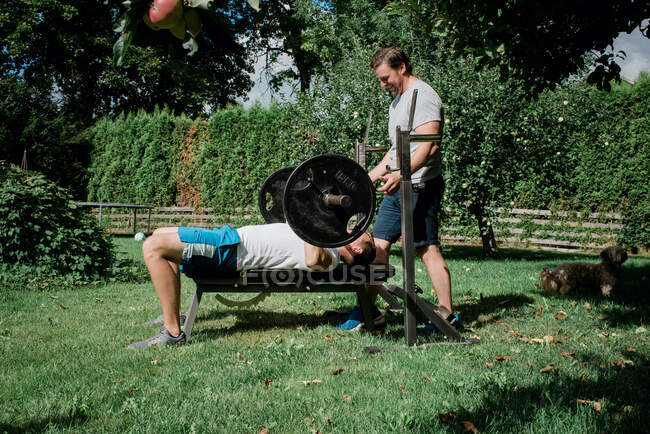 Zwei Männer trainieren gemeinsam zu Hause in der Gartenturnhalle — Stockfoto