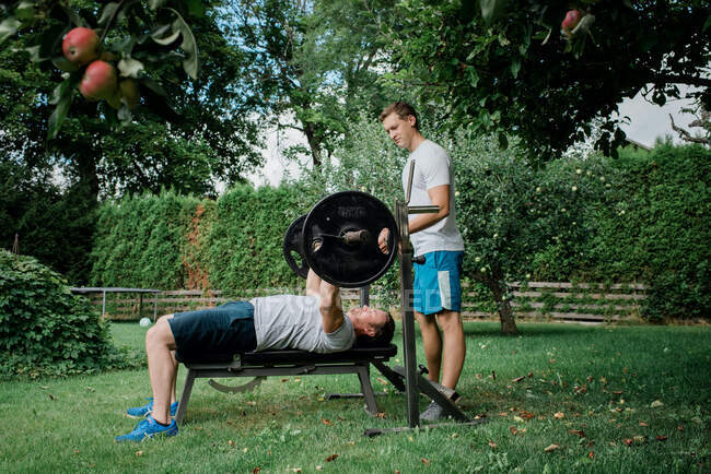 Two men working out together at home outside in the garden — Stock Photo